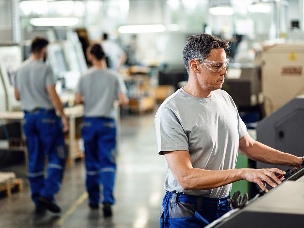 Man working in a manufacturing workplace wearing goggles