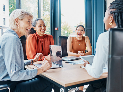 Laughing, planning business and women in a meeting for strategy, teamwork and a workforce team. Happy, office and diversity with people at work for a corporate collaboration and coworking together.