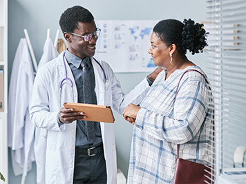 Male doctor talking with a woman patient in a doctors office