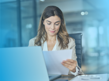 woman looking at a paper at her desk with a blue overlay